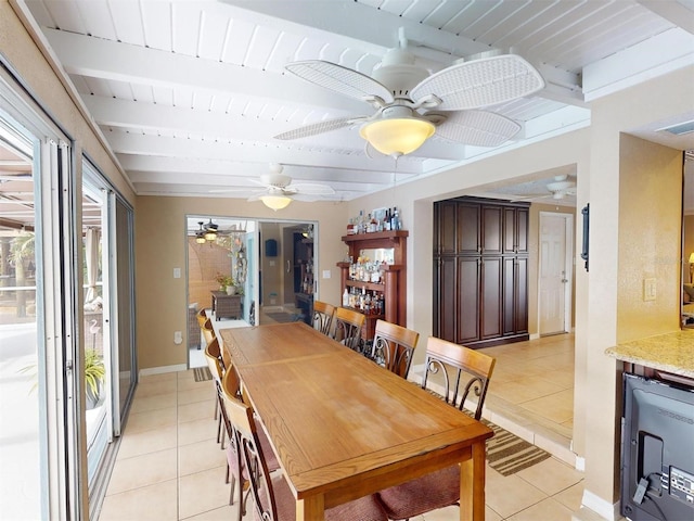 dining room featuring beam ceiling, light tile patterned floors, and wine cooler