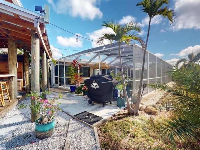 view of patio / terrace featuring glass enclosure and grilling area