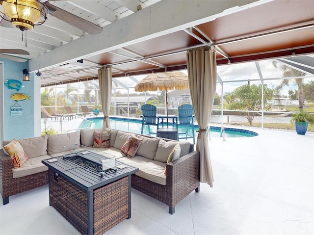 view of patio with glass enclosure and an outdoor living space with a fire pit