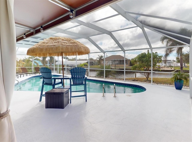 view of swimming pool with a patio, a water view, and a lanai