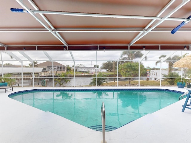 view of pool with a patio, a water view, and glass enclosure