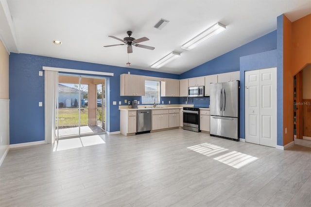 kitchen with lofted ceiling, sink, light hardwood / wood-style flooring, ceiling fan, and appliances with stainless steel finishes