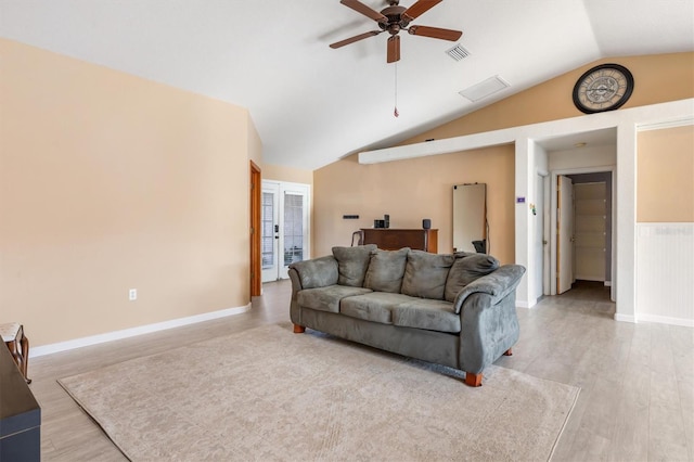 living room with ceiling fan, lofted ceiling, and light wood-type flooring