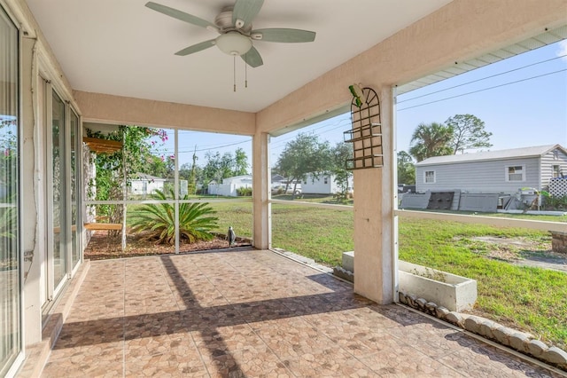 unfurnished sunroom featuring ceiling fan