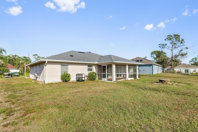 back of property featuring a sunroom and a yard