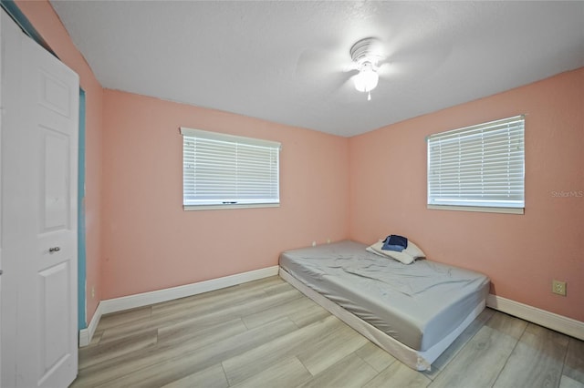 bedroom with ceiling fan and light wood-type flooring