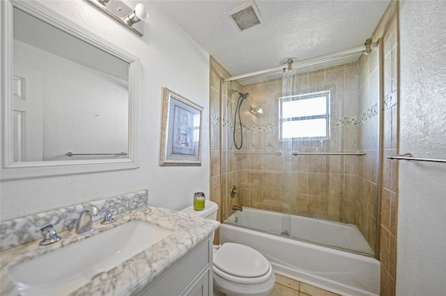 full bathroom with tile patterned floors, vanity, a textured ceiling, enclosed tub / shower combo, and toilet