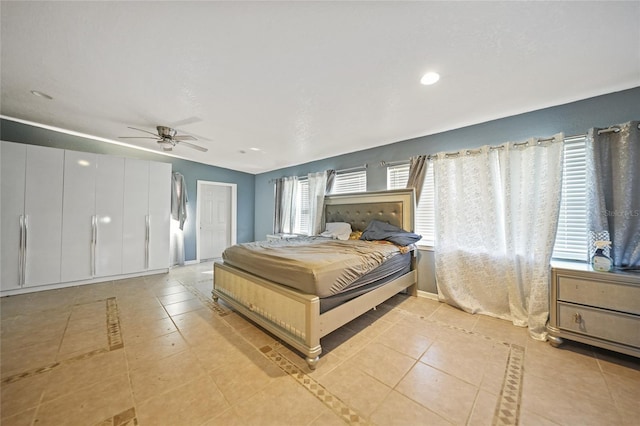 bedroom with multiple windows, light tile patterned floors, and ceiling fan