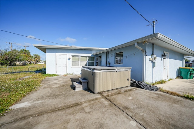 rear view of house featuring a patio area and a hot tub