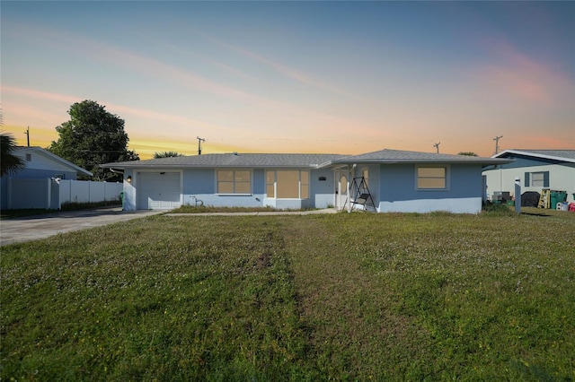 ranch-style house featuring a yard and a garage