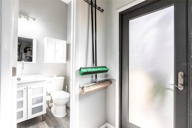 bathroom with hardwood / wood-style flooring, vanity, and toilet