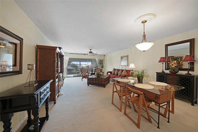 dining area featuring ceiling fan and light colored carpet