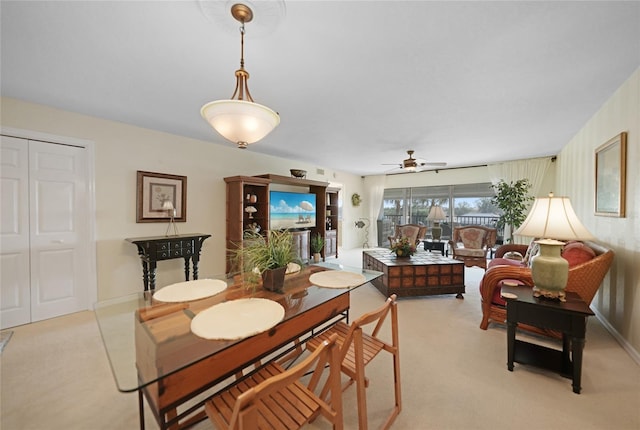 carpeted dining space with ceiling fan