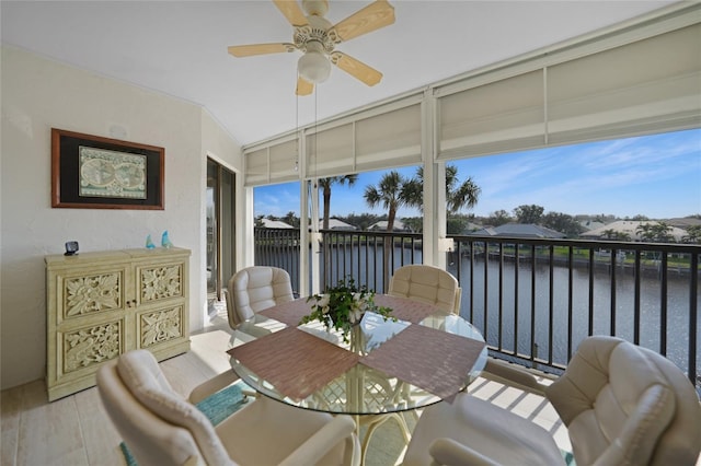 sunroom with ceiling fan, a wealth of natural light, and a water view