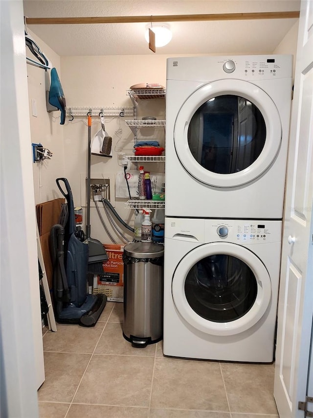 washroom featuring stacked washer / dryer and light tile patterned floors