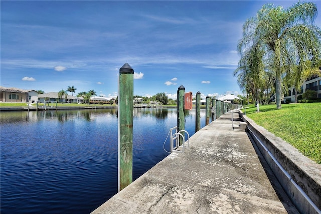 dock area with a water view and a yard