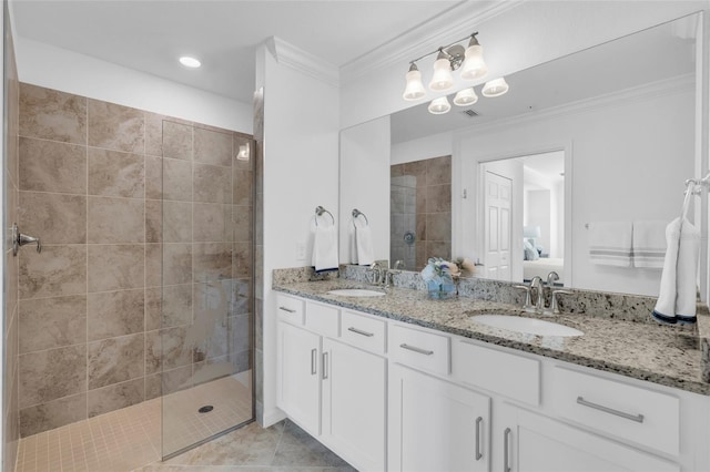 bathroom featuring tile patterned flooring, vanity, a tile shower, and crown molding