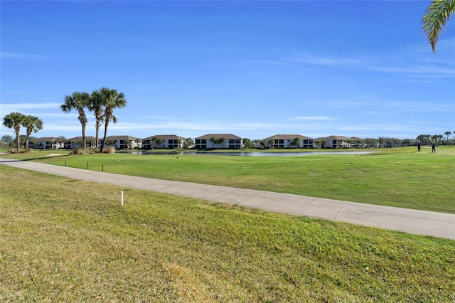 view of property's community with a yard and a water view