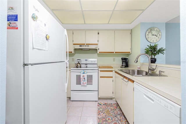 kitchen featuring cream cabinetry, light tile patterned floors, white appliances, and sink