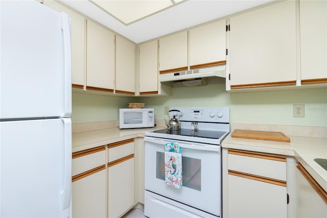 kitchen with white cabinetry and white appliances