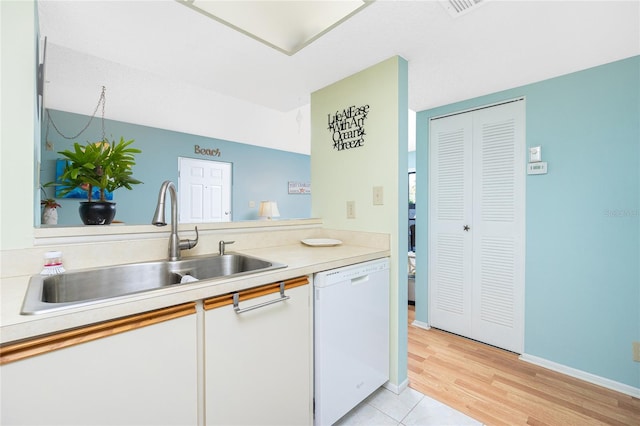 kitchen with white cabinets, dishwasher, light hardwood / wood-style floors, and sink