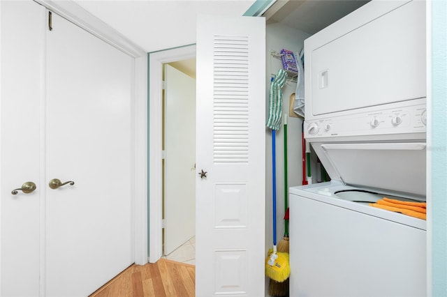 laundry area featuring light hardwood / wood-style flooring and stacked washer and clothes dryer