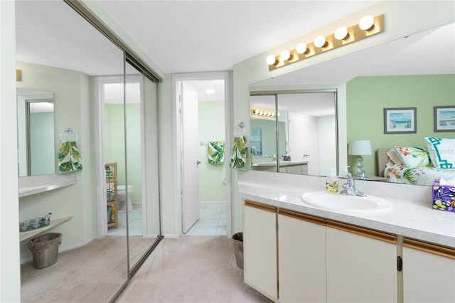 bathroom featuring vanity, a textured ceiling, and toilet