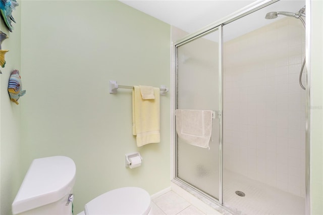 bathroom featuring tile patterned flooring, toilet, and a shower with shower door