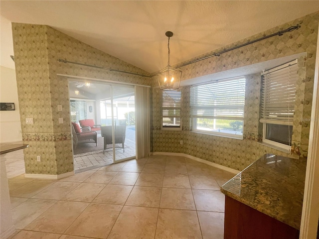 unfurnished dining area featuring light tile patterned flooring, lofted ceiling, and a notable chandelier