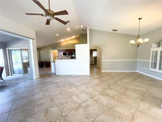 unfurnished living room with ceiling fan with notable chandelier, light tile patterned flooring, and lofted ceiling