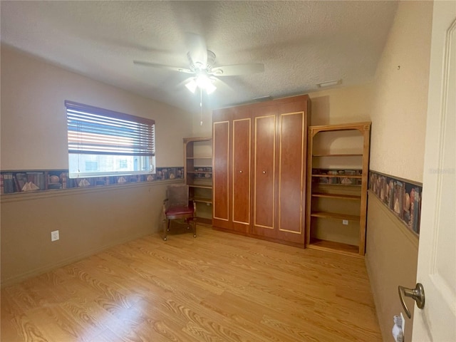 unfurnished bedroom with ceiling fan, light hardwood / wood-style floors, and a textured ceiling