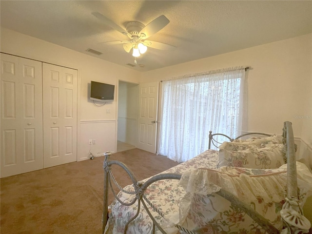 carpeted bedroom featuring ceiling fan and a closet