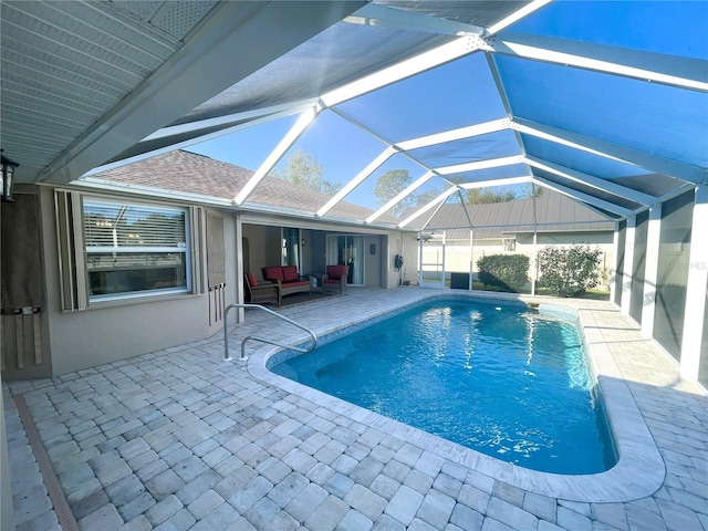 view of pool featuring glass enclosure, a patio area, and an outdoor living space