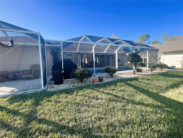 rear view of property with a yard, a patio, and a lanai