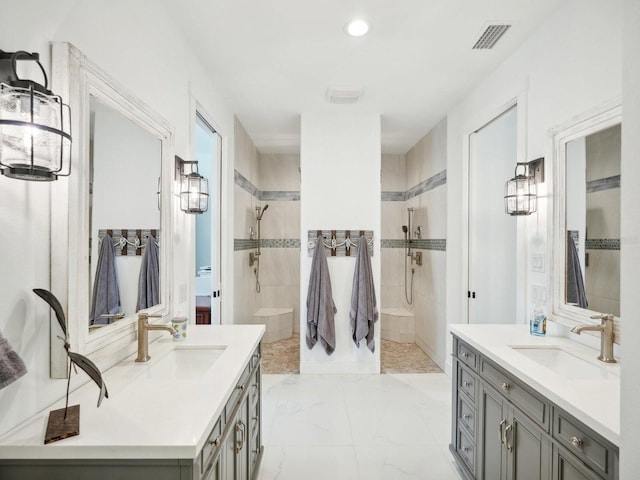 bathroom featuring a tile shower and vanity