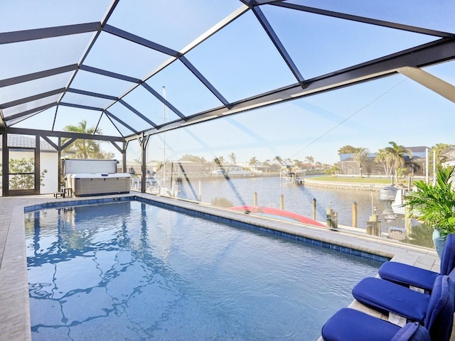 view of pool with glass enclosure, a patio area, a water view, and a hot tub