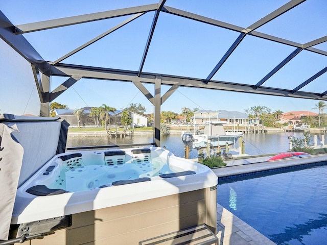 exterior space with glass enclosure, a water view, and a hot tub