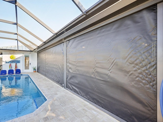 view of swimming pool featuring a lanai and a patio area