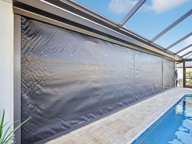 view of swimming pool featuring a lanai