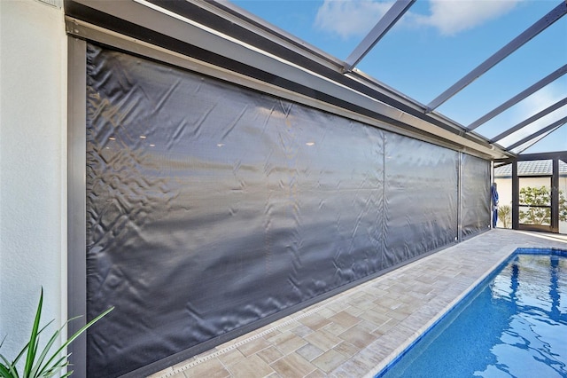 pool featuring glass enclosure and a patio