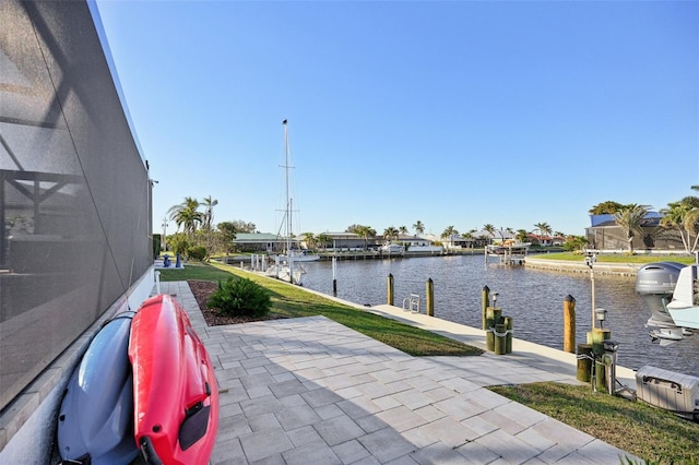 view of patio with glass enclosure, a boat dock, and a water view