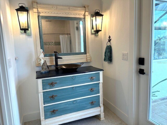 full bathroom featuring curtained shower, vanity, and baseboards