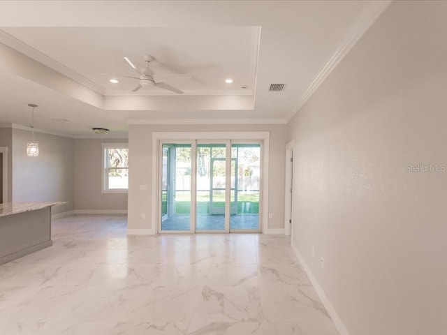 empty room featuring a raised ceiling, ceiling fan, and crown molding