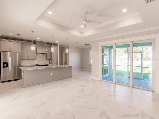 kitchen with gray cabinets, stainless steel fridge, and a raised ceiling