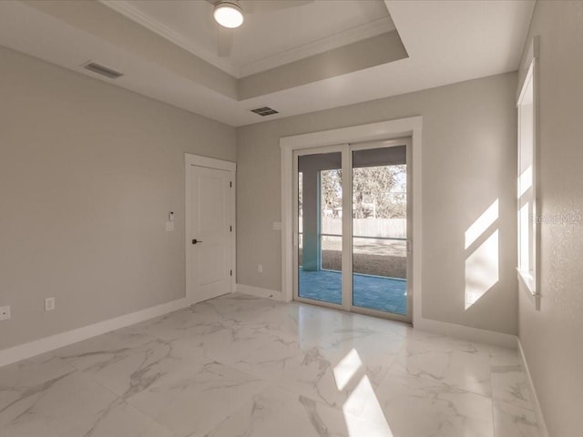 empty room featuring a raised ceiling, ceiling fan, and ornamental molding