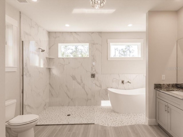 full bathroom with toilet, vanity, separate shower and tub, and tile walls