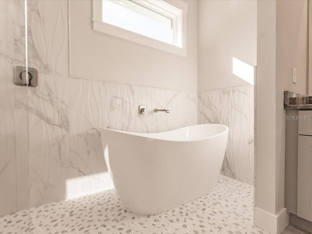 bathroom with plus walk in shower, vanity, and tile walls