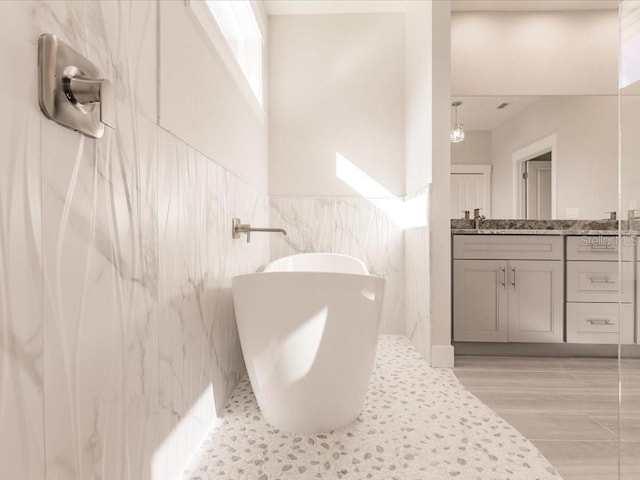 bathroom with vanity, hardwood / wood-style flooring, tile walls, and a bathing tub