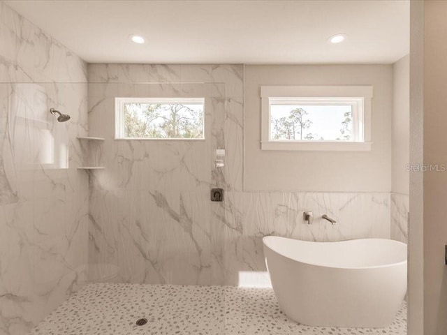 bathroom with shower with separate bathtub, tile walls, and a wealth of natural light