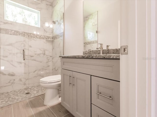 bathroom with vanity, toilet, and an enclosed shower